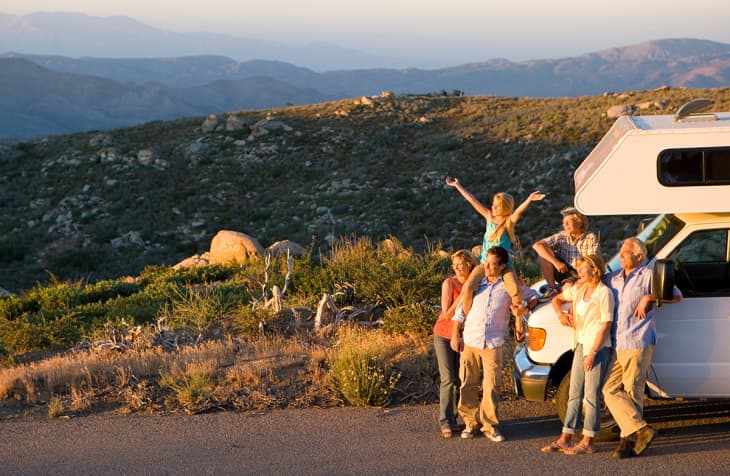 multigenerational family standing in front of RV