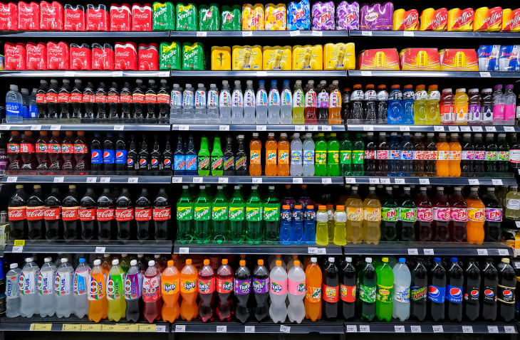 Variety of energy drinks, soda, soft drinks, with various brands product in bottles and cans on the shelves in a grocery store supermarket.