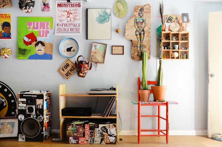 a casual gallery wall with different types of art and textiles
