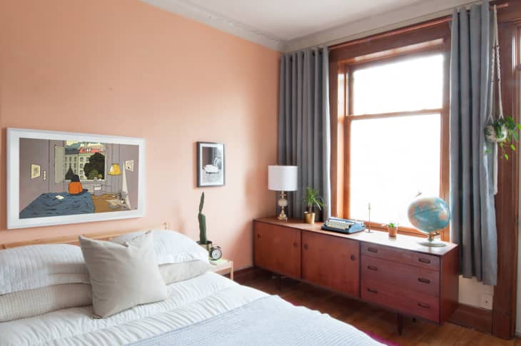 peachy pink bedroom walls with warm wood furniture