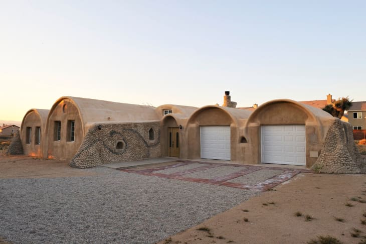 Exterior of Super Adobe home with two car garage.