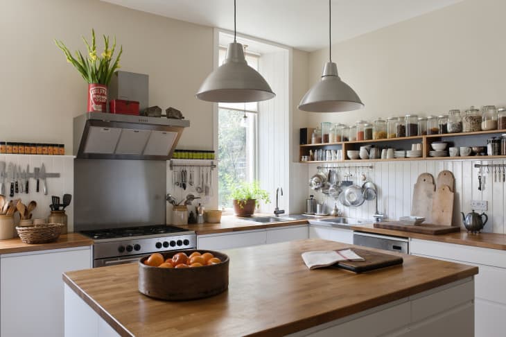 Spacious kitchen with open shelving and solid oak work surfaces. The pendant lights and units are both by Ikea.