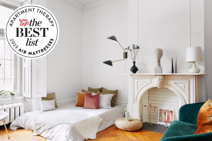 white stylish room with mattress with white linens and throw pillows on floor with seal in upper left that reads "Apartment Therapy the Best List 2023 Air Mattresses"