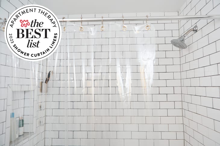 White tile and black grout shower with clear curtain liner. Seal in upper left corner reads 