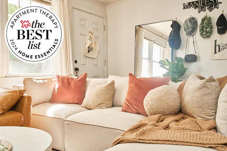 Sunny white living room with comfy sofa and throw pillows and blankets with Best list home essentials 2024 seal in upper left