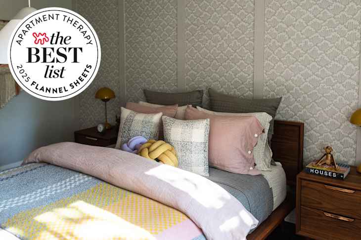 Cozy bedroom with warm bedding and striped sheets with Best List seal in upper left