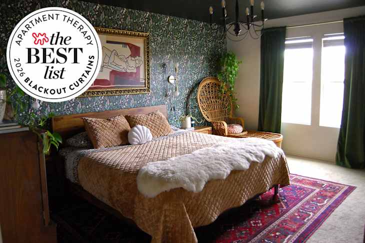 Bedroom with green floral wallpaper and wicker chair in corner beside bed. Bed is made with tan velvet blanket and animal print linens. Red and blue rug lines floor.