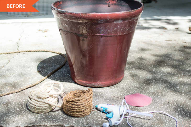 "before" photo of burgundy-colored planter sitting on asphalt. Supplies (rope, glue gun) sitting on ground in front