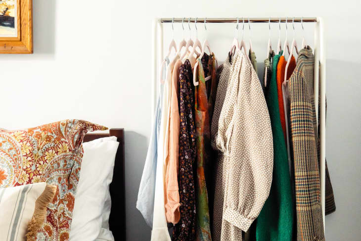 Vintage clothes on a rack by a bed