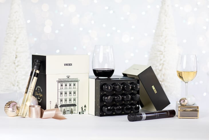 Vinebox wine tasting set with two glasses, one red and one white, alongside decorative holiday packaging.