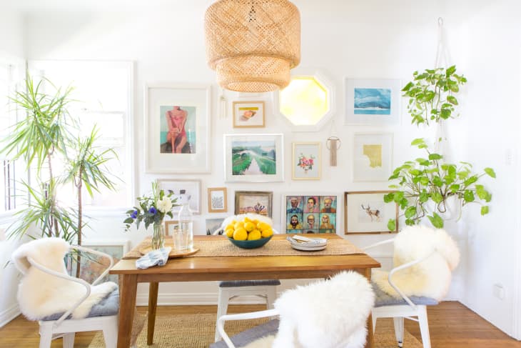 A gallery wall in a sunny bungalow's dining room