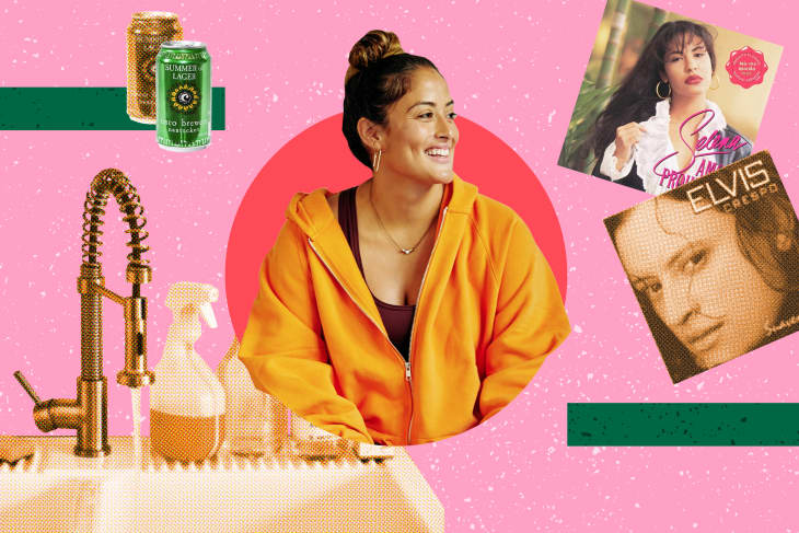 Woman in orange hoodie smiling, surrounded by a kitchen sink, cleaning spray, beer can, and two album covers.