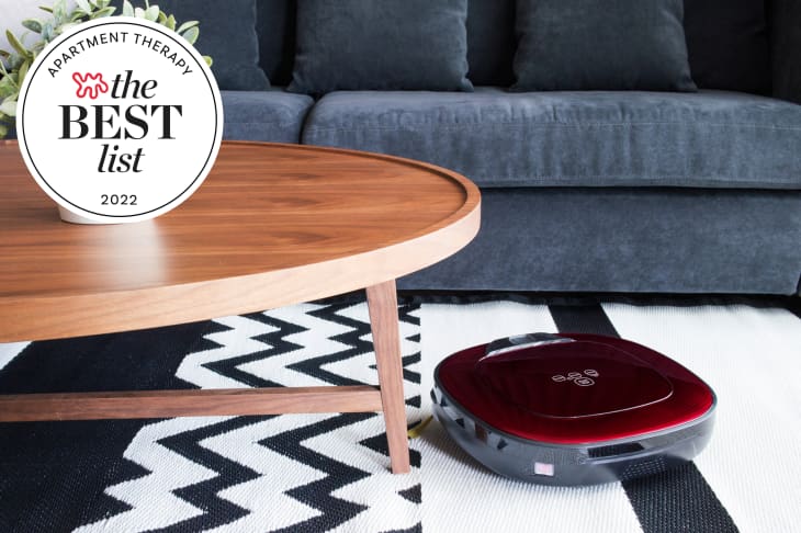 Robot vacuum on a black and white zigzag rug near a wooden coffee table and blue sofa, with a "Best List 2022" badge.