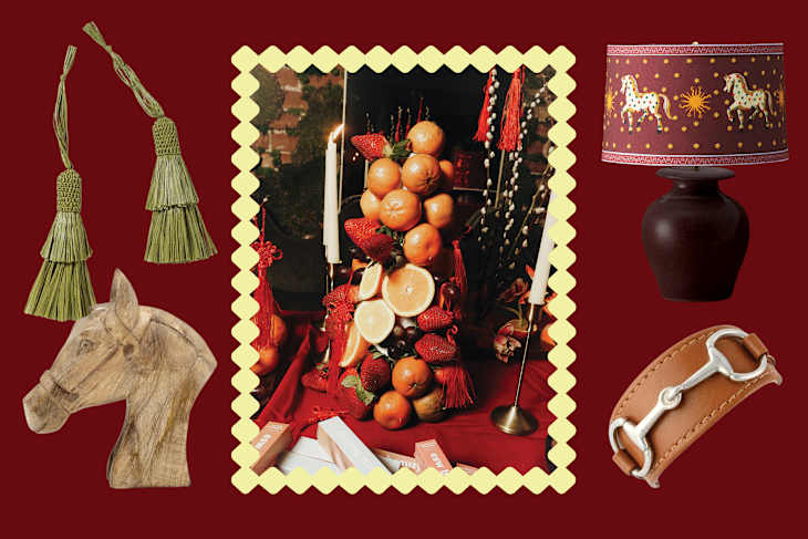 A decorative arrangement featuring a fruit tower with oranges and strawberries, green tassels, a horse head sculpture, a lamp with a horse-themed shade, and a leather bracelet.