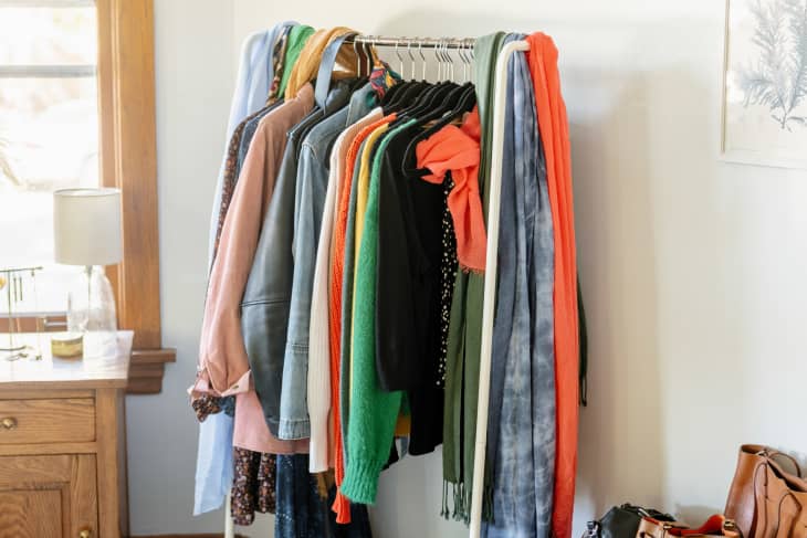 Standing clothing rack with messy scarves, stored on hooks
