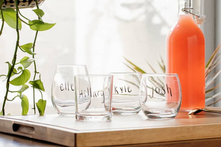 Mix of glasses on the kitchen counter with names written on them in grease pencil