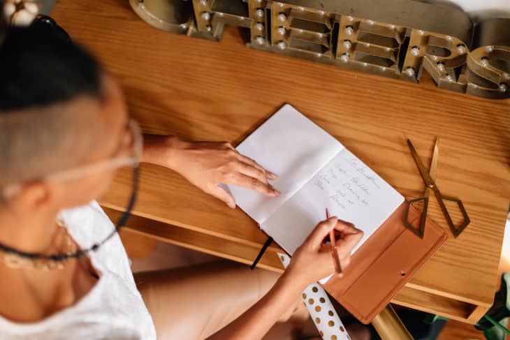 Writing into a notebook, making a list of what presents to give to people