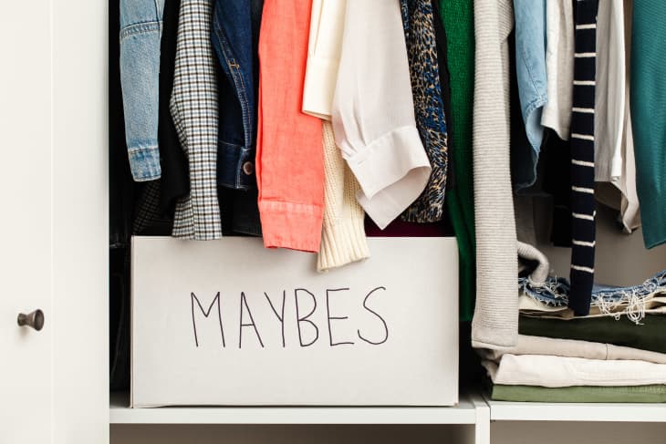 Closet full of clothes and a white cardboard box labeled "Maybes" on the bottom shelf