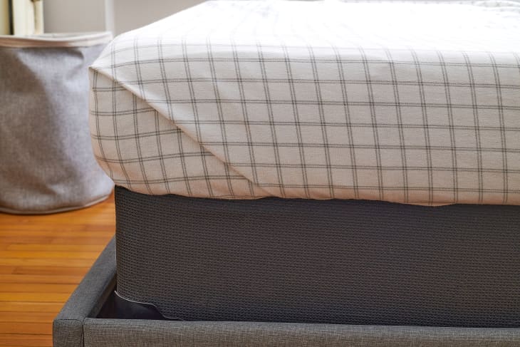 corner of bed/mattress being made showing a sheet with hospital corners
