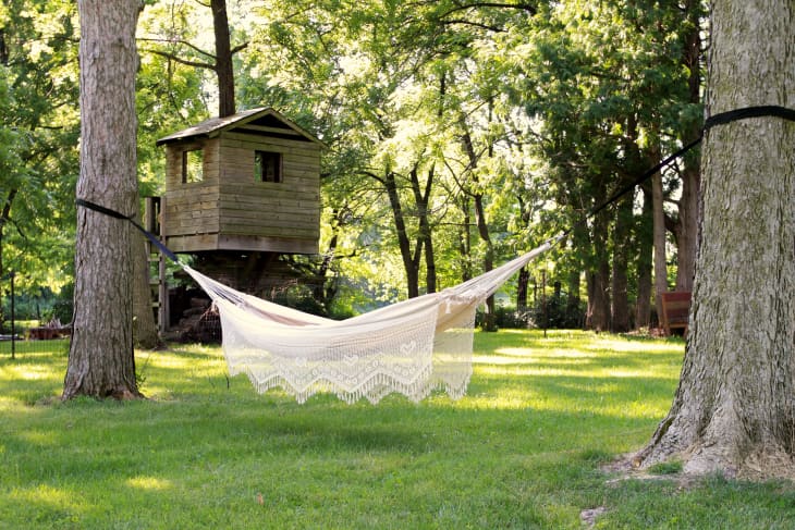 cotton fringed hammock from Home Depot mounted between two trees