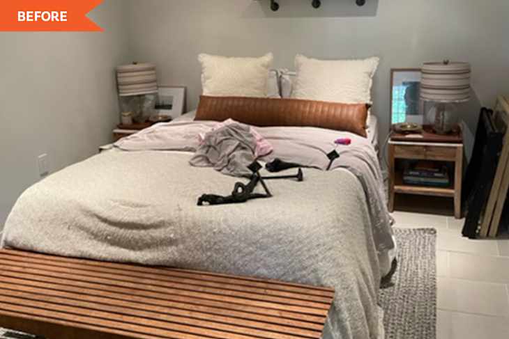 Unmade bed with beige bedding, two large pillows, wooden bench, and bedside tables with lamps and books.