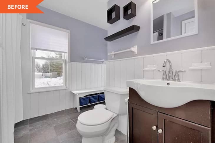 Small bathroom with white wainscoting, dark wood vanity, and wall shelves above toilet.
