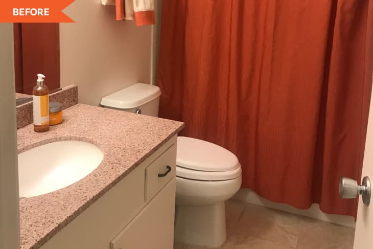 Bathroom with orange shower curtain, granite countertop, white sink, and toiletries on the counter.