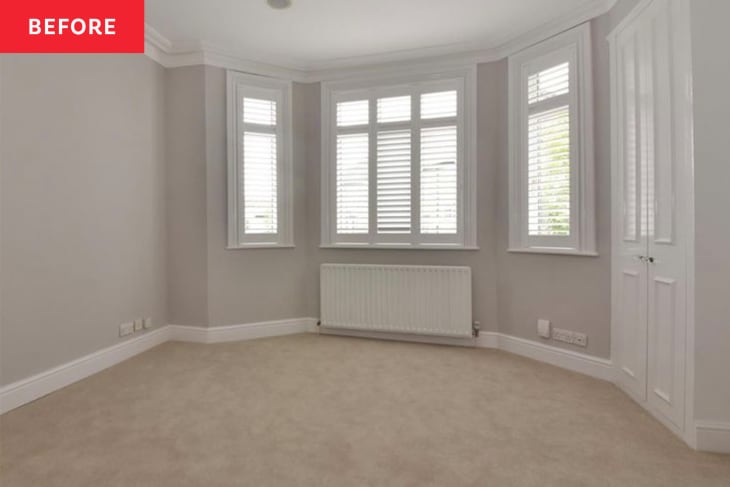 Bedroom before makeover. pale gray walls, beige carpet, bay windows, tall white cabinet