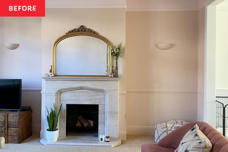 Vintage mirror over fireplace in light colored living room with pink sofa and carpeted floors.