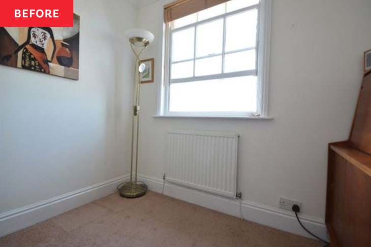 Floor lamp in corner of bedroom with artwork on wall before renovation.