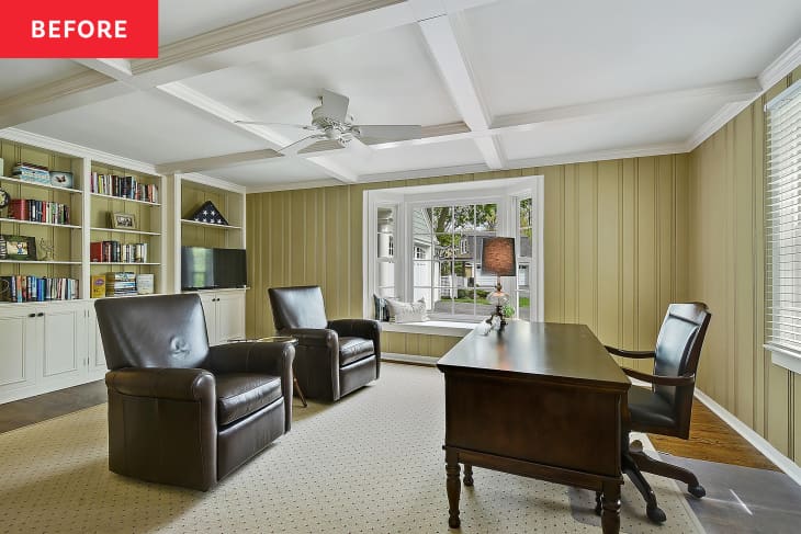 Dark brown chairs and wooden desk in neutral library with built-in shelves and beamed white ceiling.