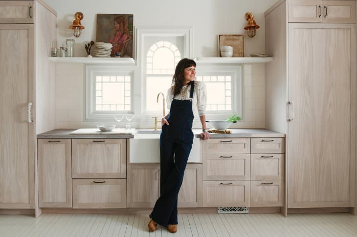 Leanne Ford leaning against kitchen cabinets with whitewash oak shaker doors.