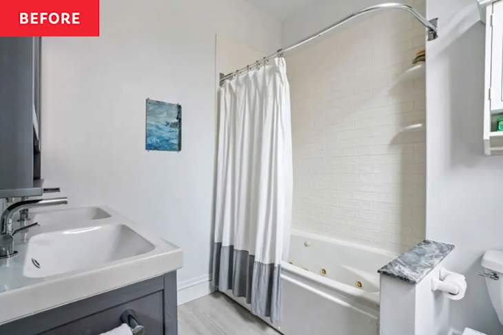 Bathroom with a white shower curtain, gray cabinetry, a double sink, and a jetted tub against a white tiled wall.