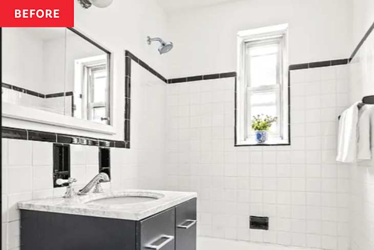 Bathroom with white tiled walls, black accents, a marble sink, and a small window with a potted plant.
