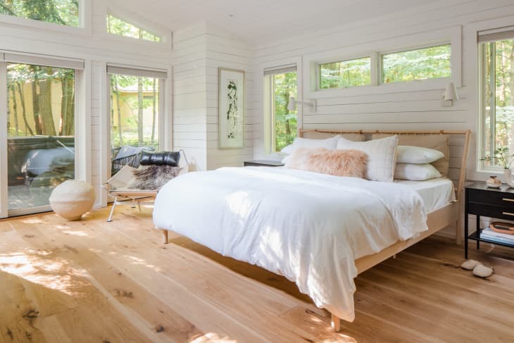 A White and light wood bedroom with white shiplap covering the walls