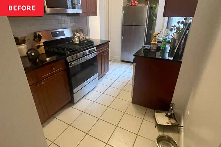 White stone tile floors in kitchen with dark wooden cabinets and black countertop surfaces before renovation.