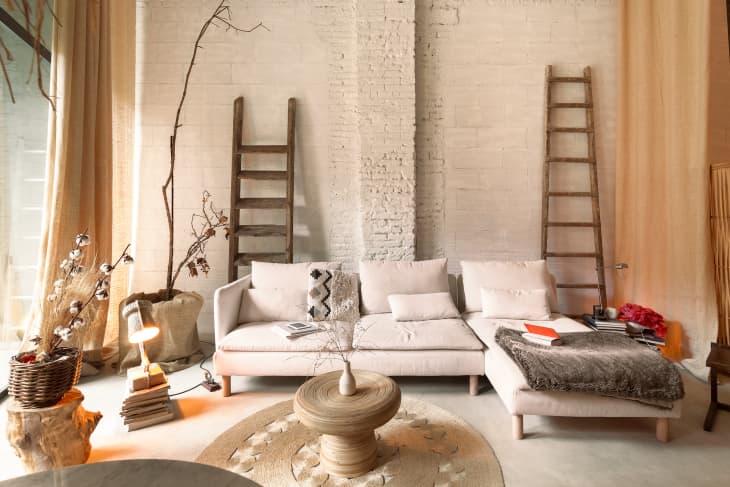 White brick living room with off white sofa and lots of warm neutral elements
