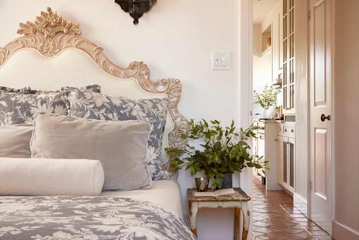 A bedroom with a large bed with blue floral decorations matching the headboard.