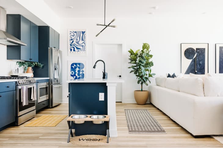White kitchen with blue cabinets and blue and white art