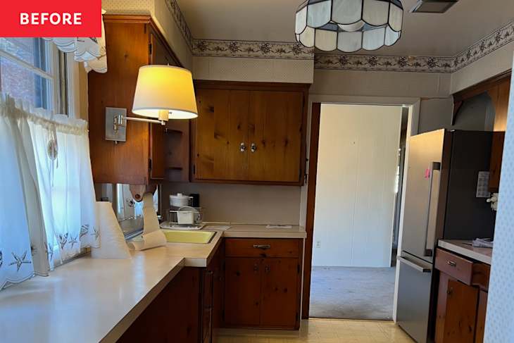 1960s kitchen with dated wallpaper and wood cabinets