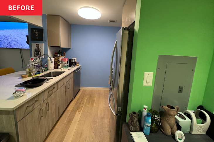 Kitchen with light wood cabinets, blue wall, stainless steel appliances, and green accent wall. Countertop cluttered with items.