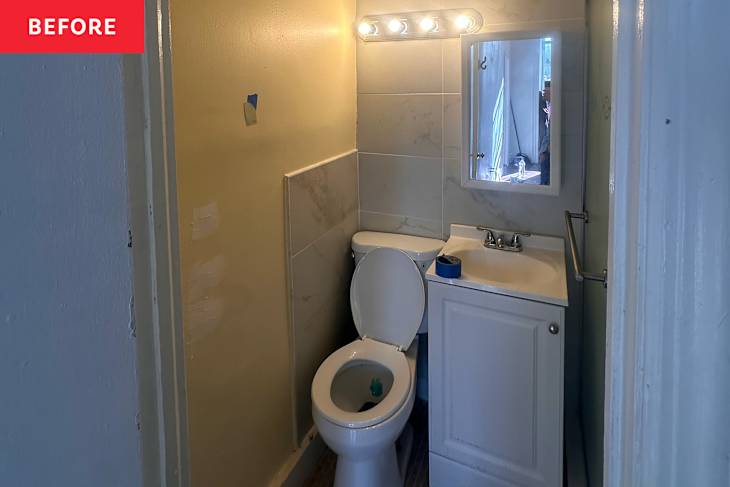 Small bathroom with a toilet, sink, and a mirror, featuring unfinished walls and lighting above the mirror.