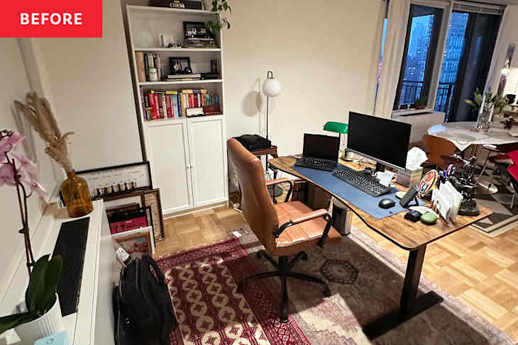 A cozy home office with a wooden desk, two monitors, a brown swivel chair, and a bookshelf filled with books.