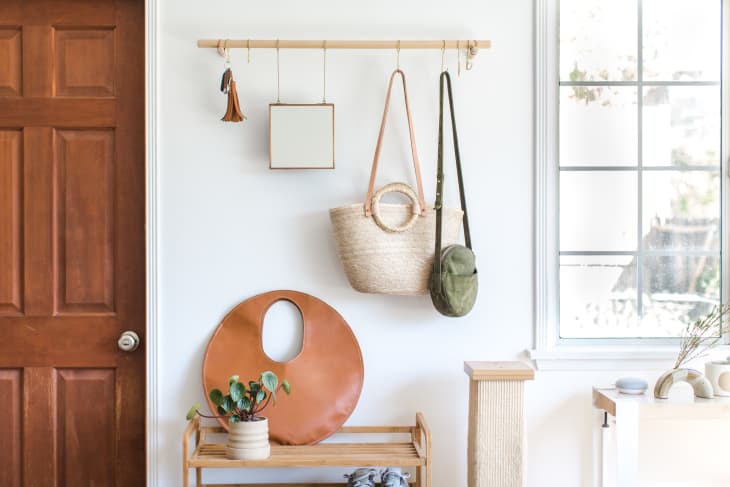 A round brown handbag is placed on top of a shoe rack, while two  handbags are hung on the wall making it a statement decor
