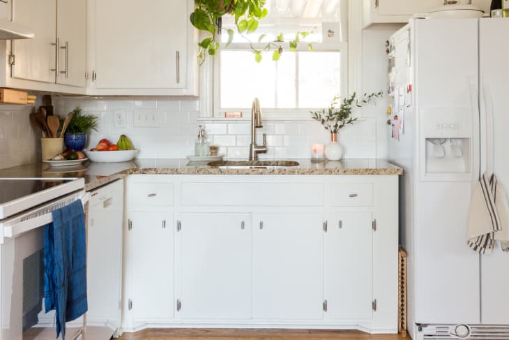 white kitchen sink area with tile backsplash and window
