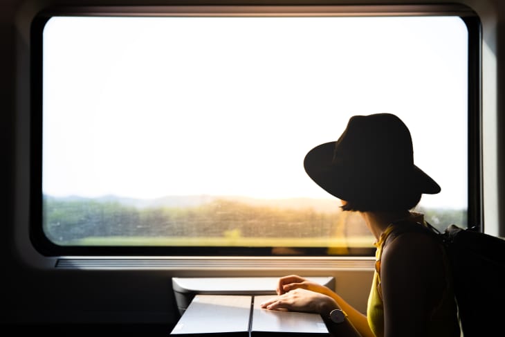 Woman wearing hat looking out train window