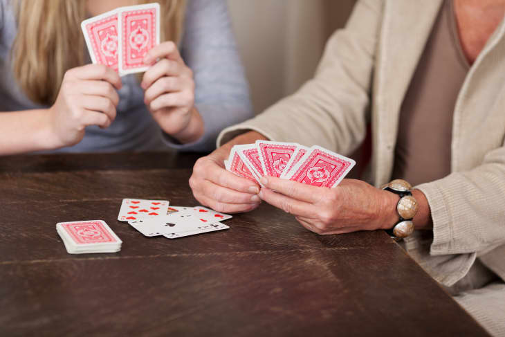 Two people sitting at table playing cards