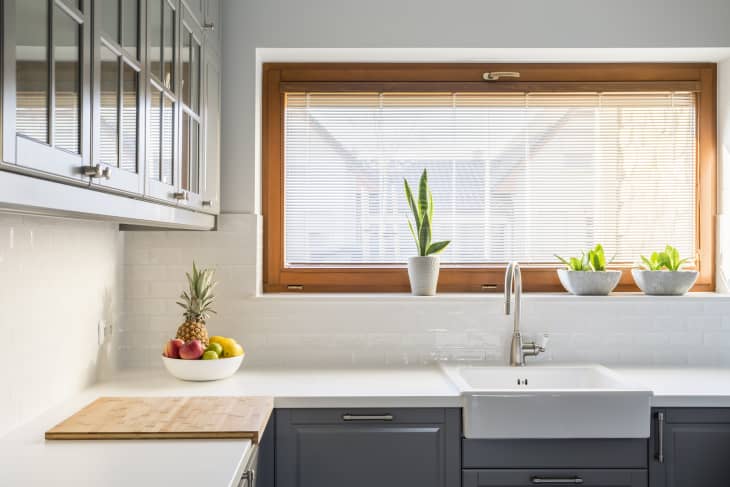 Sunny kitchen with white counters and window above sink