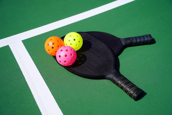 Close up of pickleball paddles and balls on court