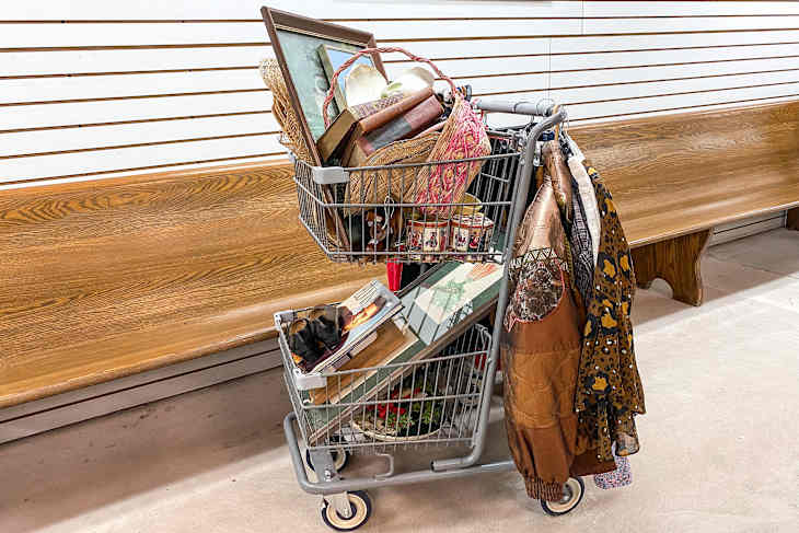 Shopping cart filled with items at thrift store.